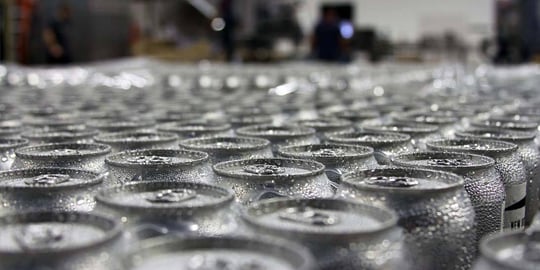 tops of a bunch of aluminum cans with water droplets on them